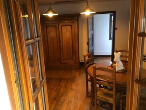 Uma área de refeições de madeira com uma mesa, cadeiras e uma decoração de coelho branco.