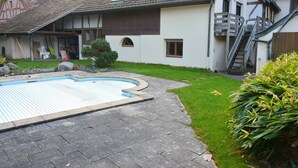 A residential property with a swimming pool, a staircase, and a small garden.