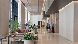 A spacious lobby with a modern design, featuring a long reception desk, comfortable seating areas, and large potted plants. - Luxury Corner 2bdcity & Bay Viewsamazing Sunsets (Miami)