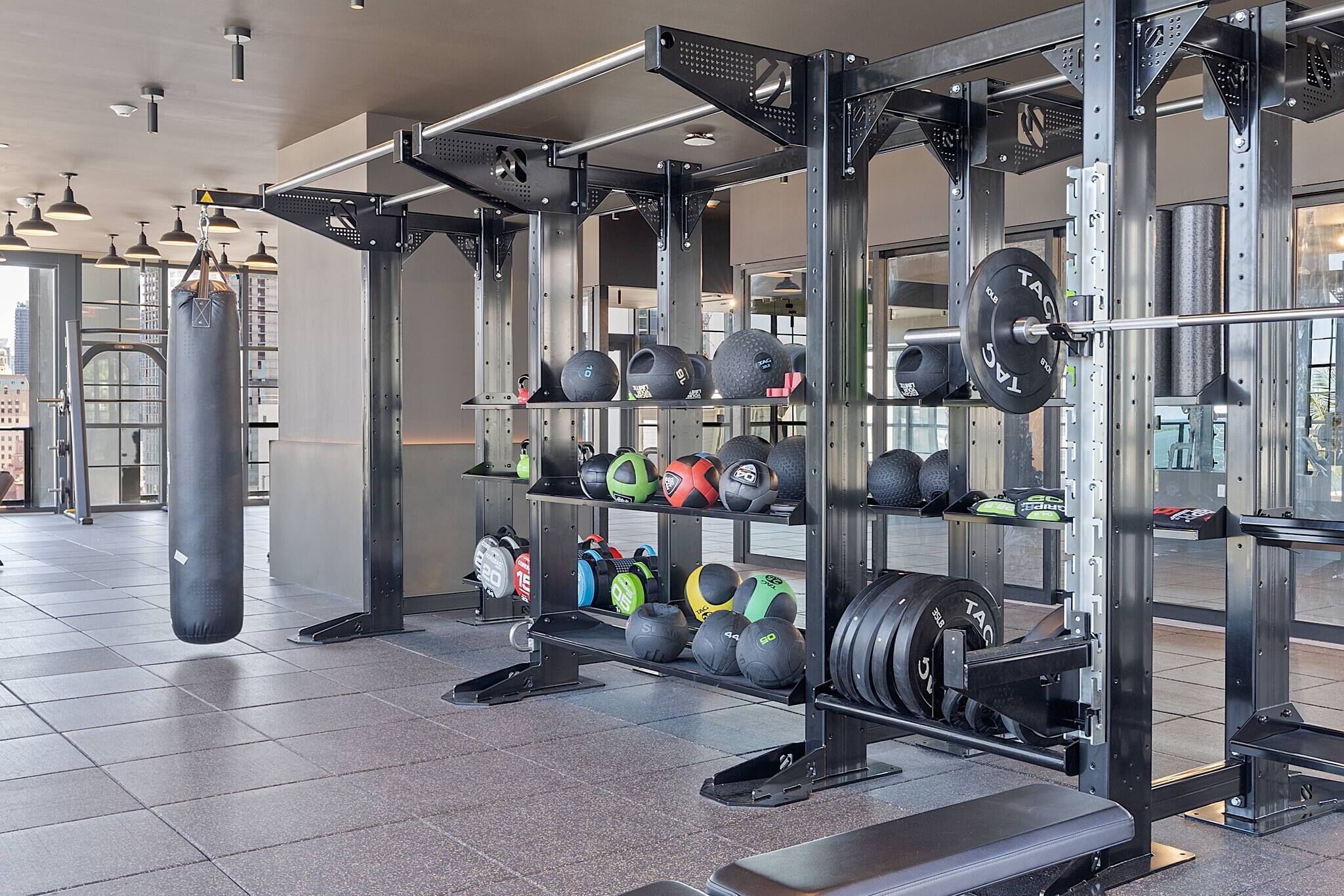 Een sportschool met krachttoestellen, waaronder een squatraam en diverse gewichten.