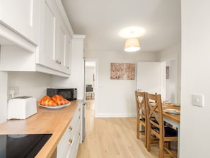 A kitchen with white cabinets, a wooden countertop, a toaster, and a plate of croissants. - 17 Clifden Court Townhouse W/ Parking (Clifden)
