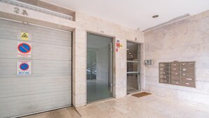 L’entrée d’un hôtel, avec une porte métallique fermée, une porte en verre et une fente pour le courrier dans le mur.