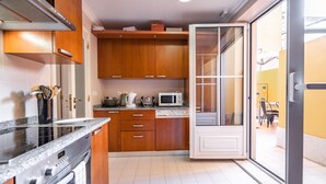 Une cuisine moderne avec des meubles en bois, un four à micro-ondes et un lave-vaisselle.