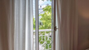 Vue depuis une chambre donnant sur un balcon par une porte-fenêtre coulissante.