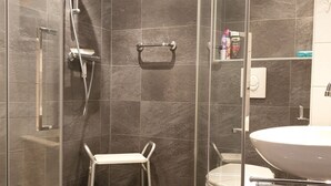 A modern bathroom with a glass-enclosed shower, a white toilet, and a sink. - 2 bedroom accommodation in Westkapelle (Westkapelle)
