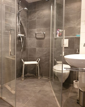 A modern bathroom with a glass-enclosed shower, a white toilet, and a sink. - 2 bedroom accommodation in Westkapelle (Westkapelle)
