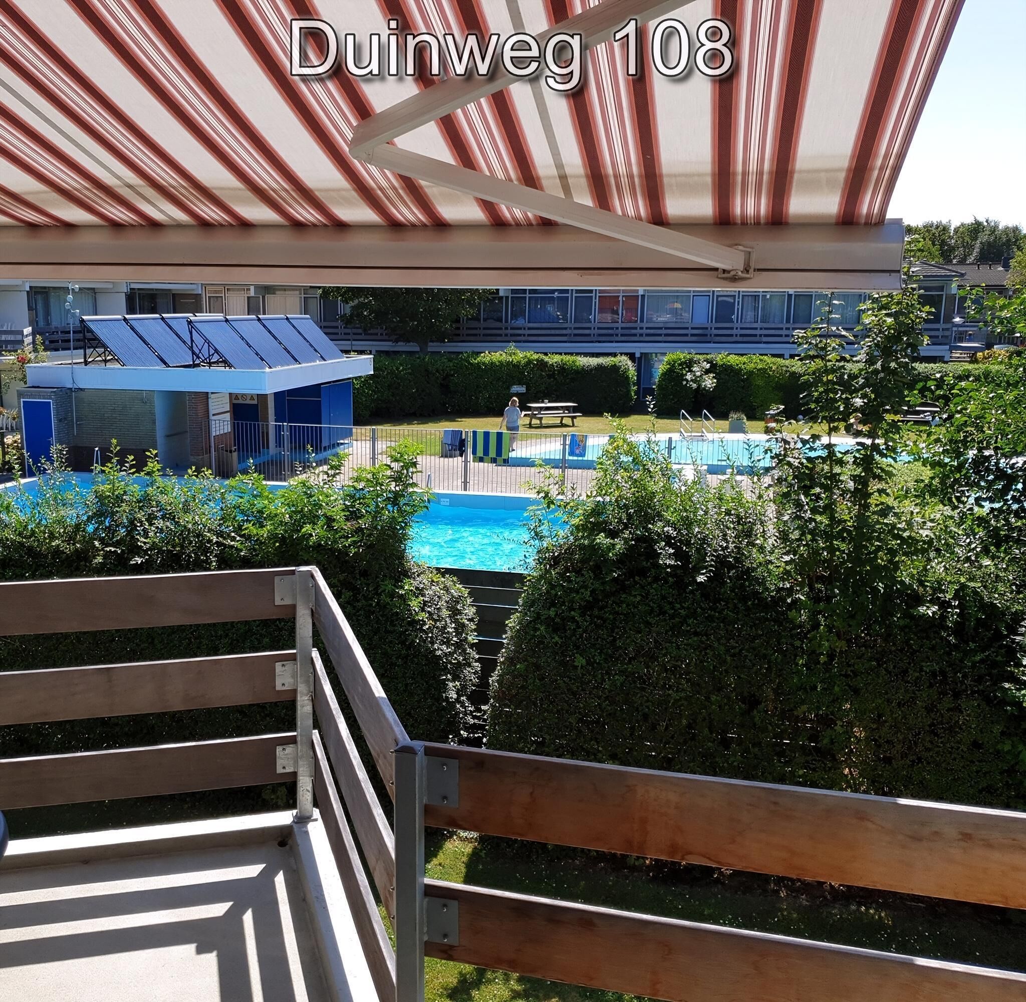 Blick auf einen Poolbereich mit überdachter Sitzgelegenheit und Solaranlage auf dem Dach.