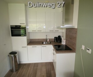 Een koelkast, een oven, een kookplaat, een vaatwasser