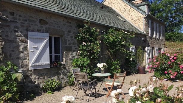 A stone house with a gravel patio, outdoor seating, and blooming roses. - Cozy house with garden, pets allowed, WiFi in La Hague (La Hague)