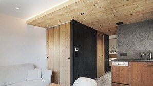 A modern kitchen with wooden cabinets, a built-in dishwasher, and a stone backsplash.