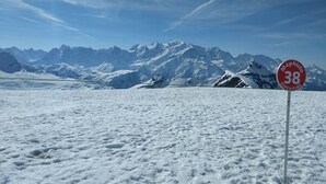 Schneebedeckte Landschaft mit einem Schild, das 'Méphisto 38 Superficie' anzeigt.