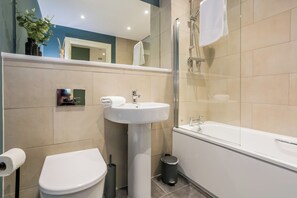 Ein modernes Badezimmer mit Toilette, Waschbecken und Badewanne.