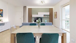 Un comedor moderno con una mesa de madera, sillas color turquesa y un jarrón con flores.