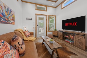 A living room with a sofa, a coffee table, a TV, and a wooden cabinet.