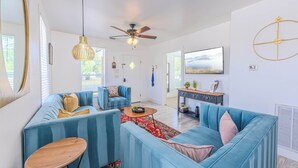 A modern living room with a sectional sofa, a wooden coffee table, and a ceiling fan.