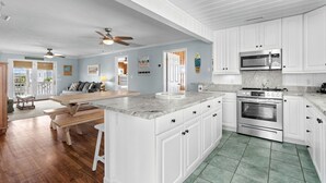 A spacious kitchen with white cabinets, a granite countertop, and stainless steel appliances. - 10% off 3-7 nights thru Oct. Pet friendly 4BR 2BA on channel. Fenced yard (North Myrtle Beach)