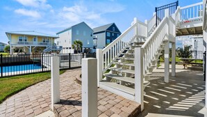 A pool area with a white staircase leading to a deck, surrounded by a fence. - 10% off 3-7 nights thru Oct. Pet friendly 4BR 2BA on channel. Fenced yard (North Myrtle Beach)