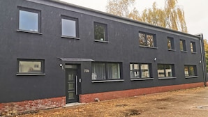 Moderni rakennus, jonka tumma julkisivu on numeroitu 73b, ja jossa on useita ikkunoita sekä tiilestä tehty pohjakerros.