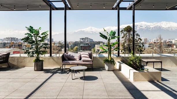 A rooftop terrace with a sofa, a small table, and potted plants. - Modern 1BR Urban Oasis in Providencia | Chic Stay (Providencia)