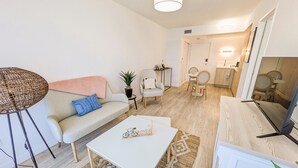 A modern living room with a sofa, coffee table, and a dining area with chairs and a table. - Résidence de Nogent sur Marne (Nogent-sur-Marne)