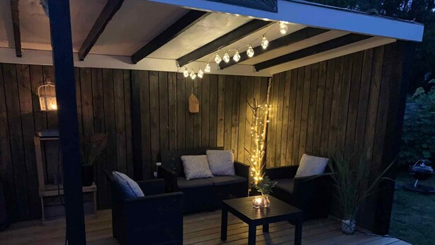 An outdoor patio with wooden flooring, a sofa set, and a table. - 5 Star Holiday Home in Ebeltoft (Ebeltoft)