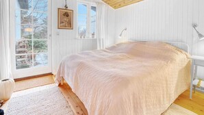 Una camera da letto con un letto grande, una finestra e un soffitto in legno.