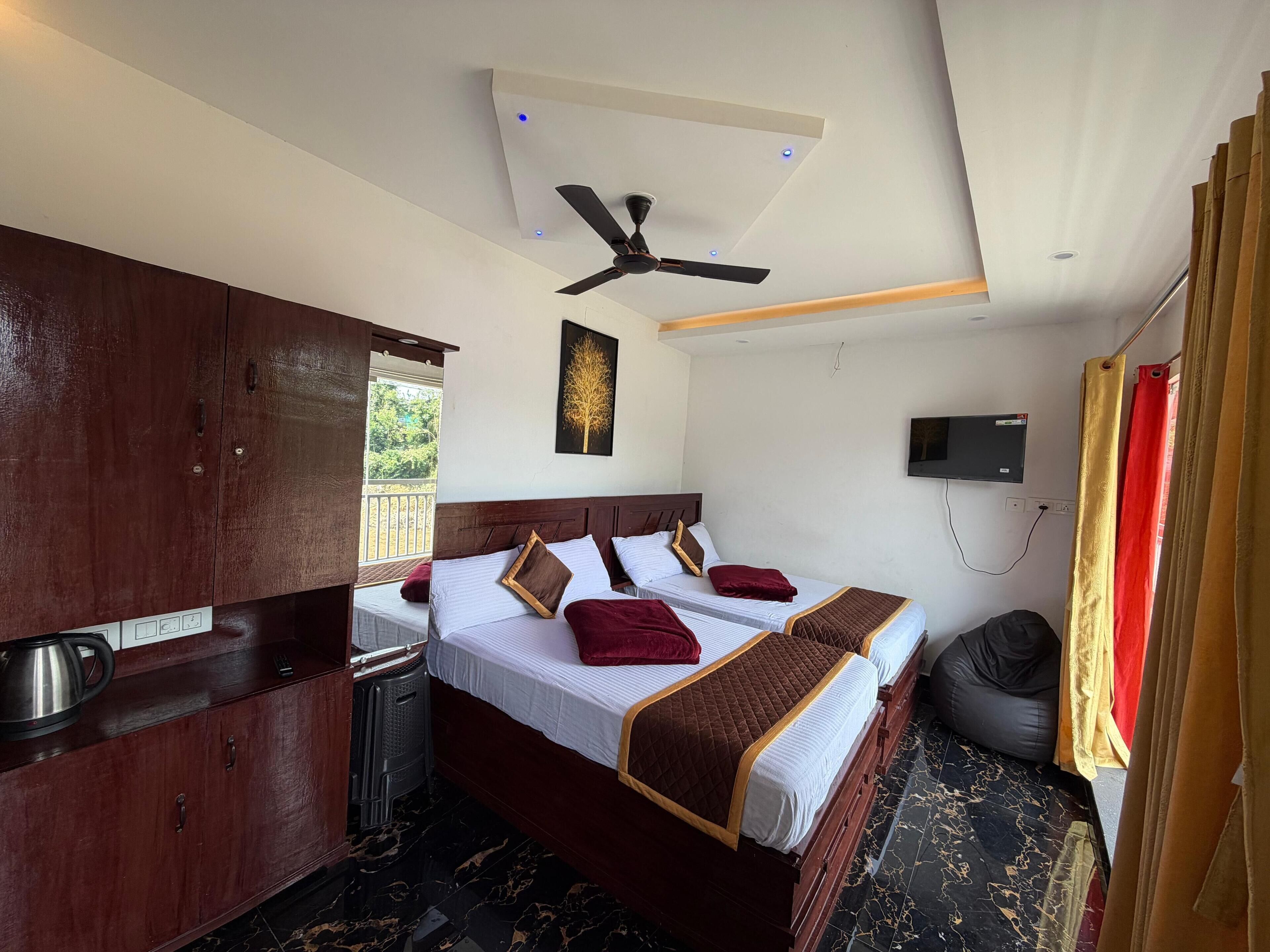 A hotel room with a bed, a ceiling fan, a TV, and a view of the outdoors.