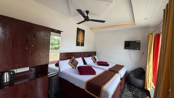 A hotel room with a bed, a ceiling fan, a TV, and a view of the outdoors.