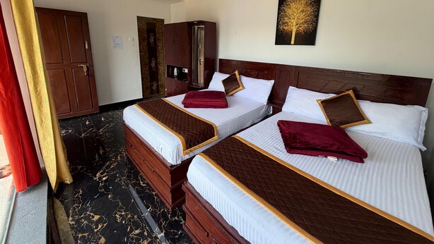 A hotel room with two beds, a ceiling fan, a painting, and a wardrobe. - Glass House Retreat (Valparai)