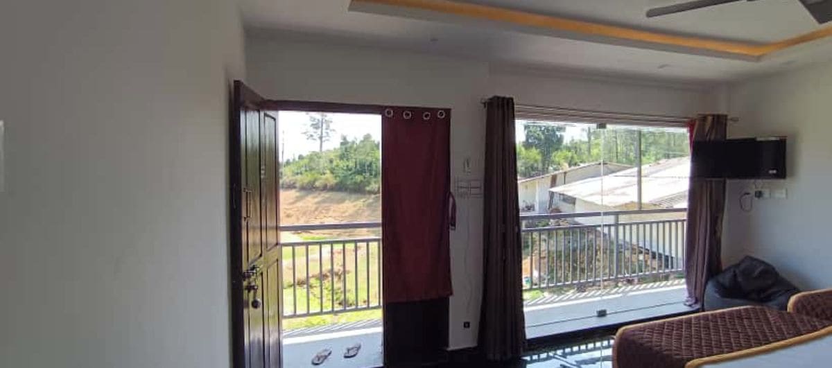 Una stanza con balcone, un letto e una televisione.
