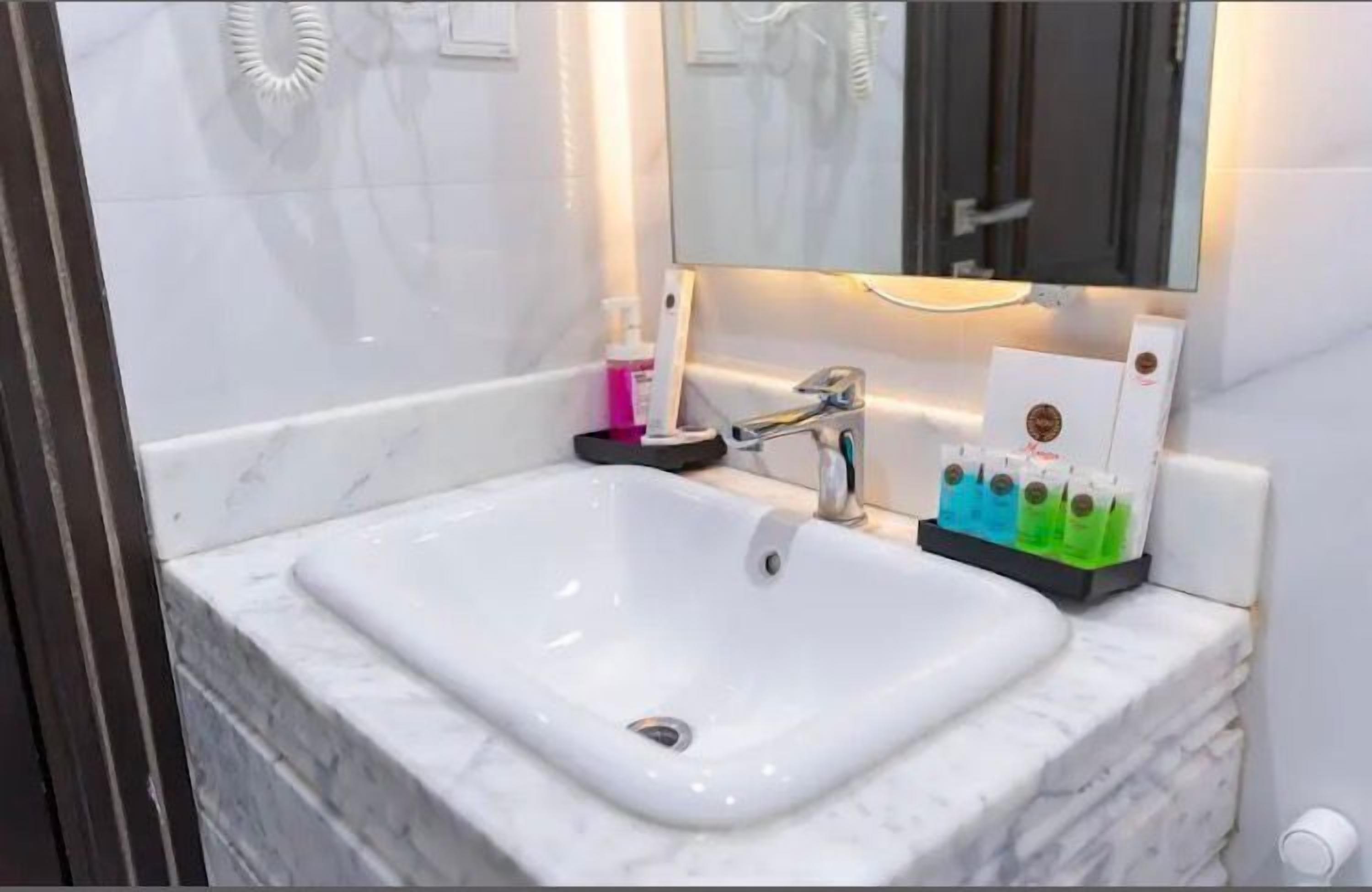 A bathroom with a white sink, a mirror, and a towel rack.