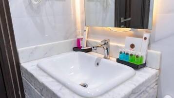 A bathroom with a white sink, a mirror, and a towel rack.