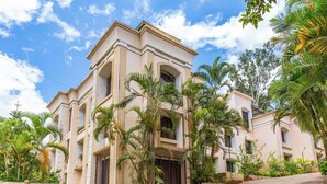 Un grand immeuble à étages, doté d’une façade symétrique, de nombreux balcons et d’une entrée fermée par un portail.