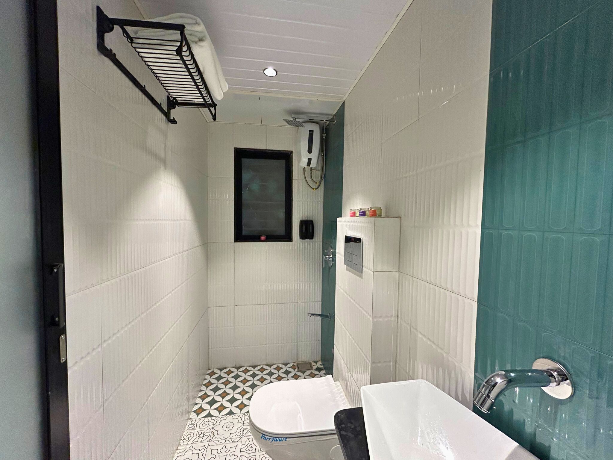 A small bathroom with a shower, toilet, and sink.