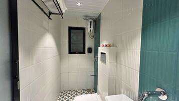 Un baño pequeño con ducha, inodoro y lavabo.