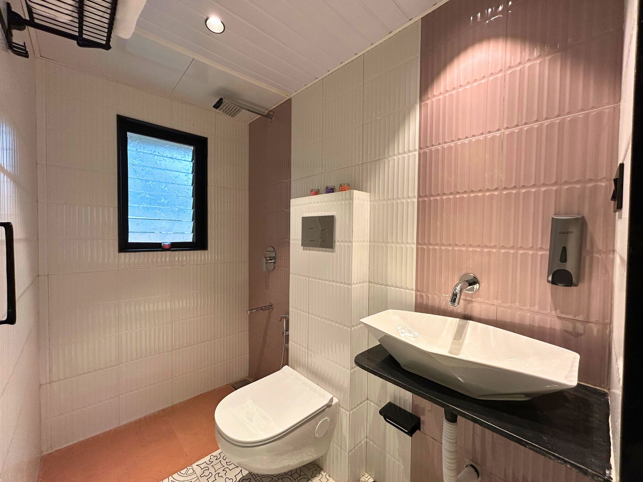 A bathroom with a toilet, sink, and window.