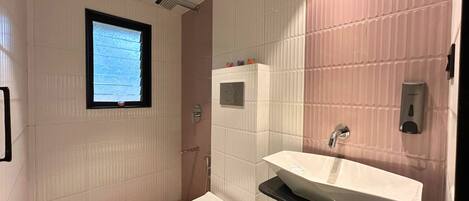 Un baño con inodoro, lavamanos y ventana.