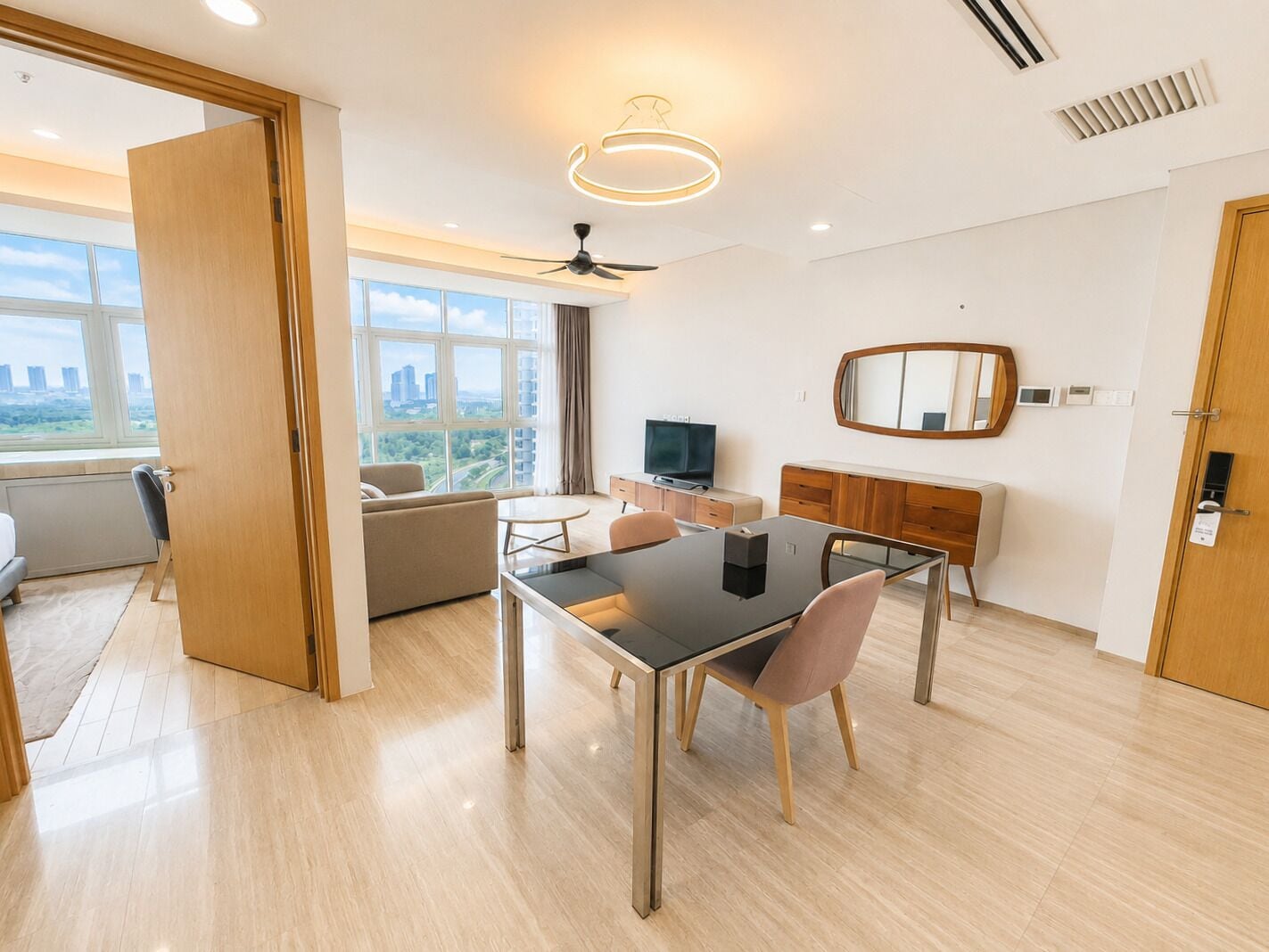 Ein modernes Wohnzimmer mit Essbereich, großen Fenstern, einem Flachbildfernseher und einem Deckenventilator.