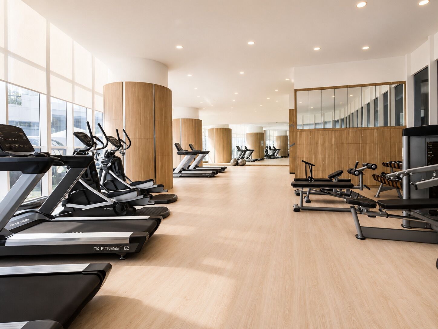 A modern gym with multiple treadmills, ellipticals, and weight machines.