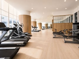 Et moderne fitnesscenter med flere løbebånd, crosstrainere og styrkemaskiner.