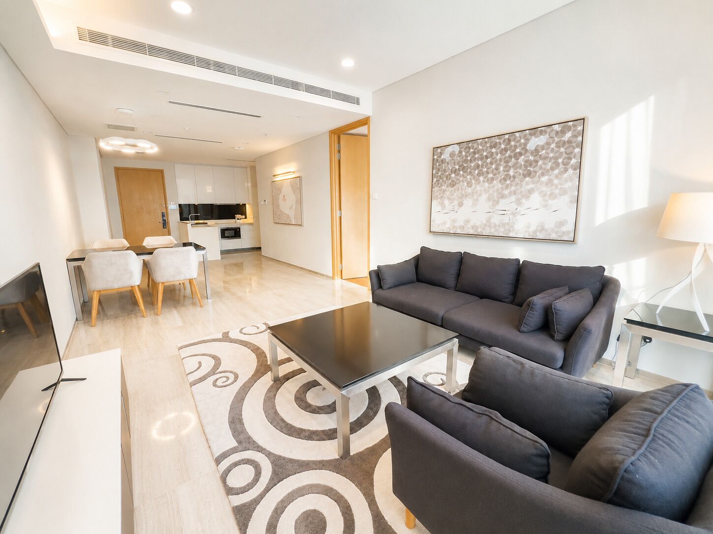 Una sala de estar moderna con un sofá, una mesa de centro y un comedor con sillas.