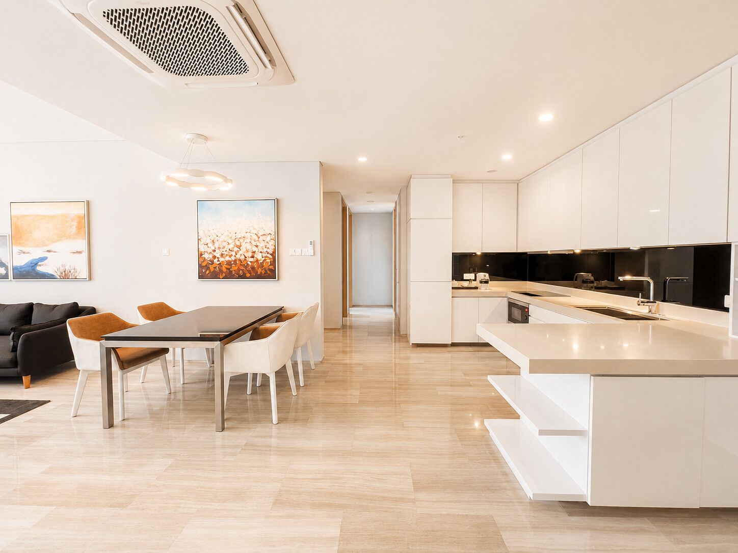 A modern kitchen with white cabinetry, a central island, and a dining area with a table and chairs.