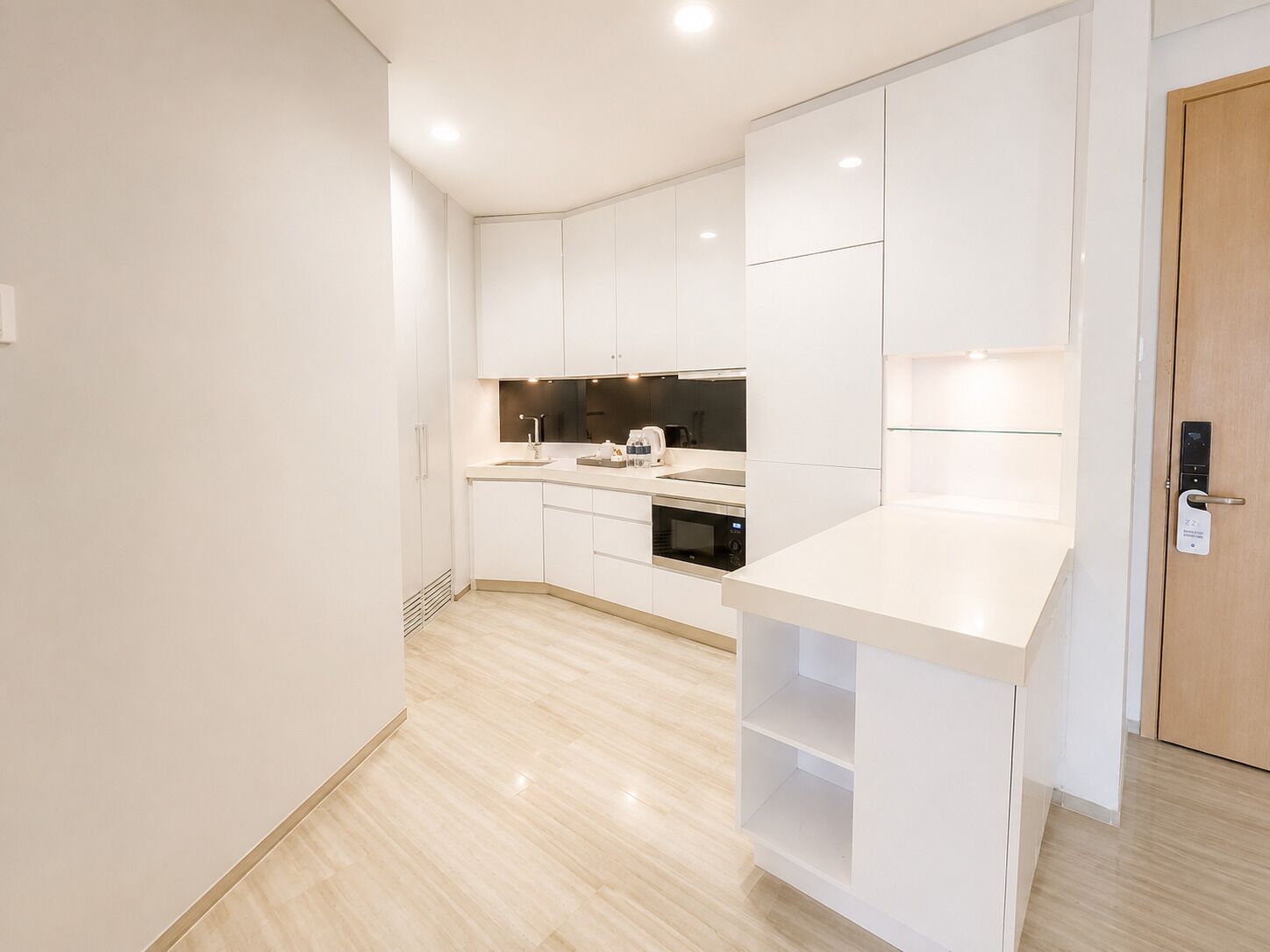A modern kitchen with white cabinetry, a built-in oven, and a countertop.