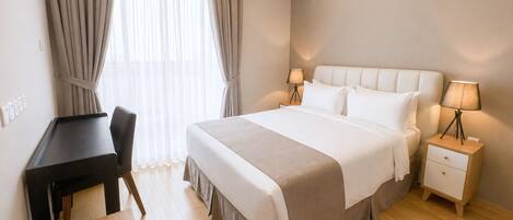 A hotel room with a bed, bedside tables, a desk, and curtains.