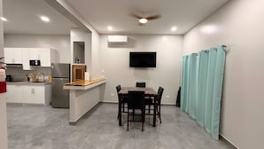 A modern kitchen with white cabinets, a built-in microwave, and a stainless steel refrigerator.