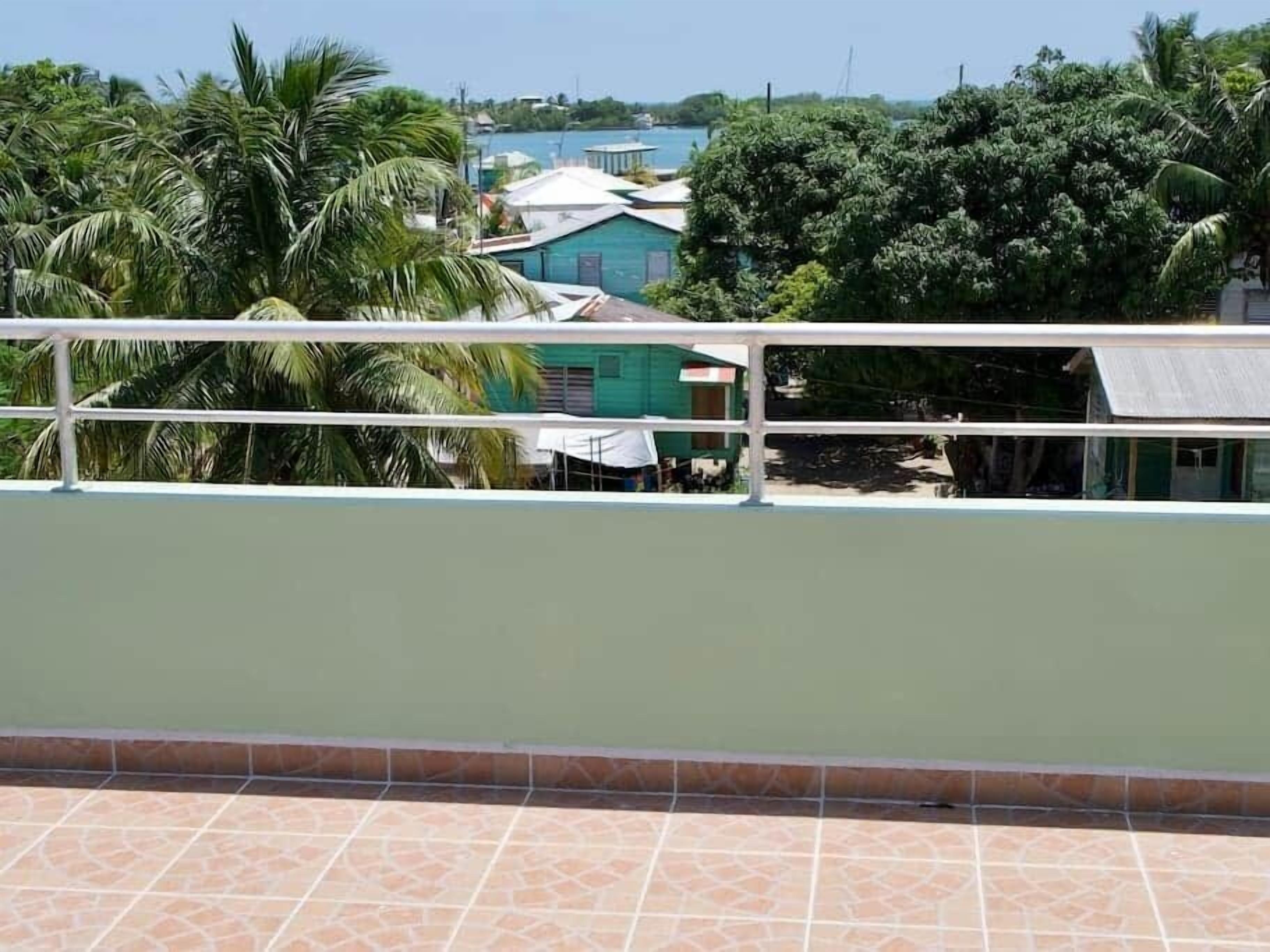 Un balcón con vista a una zona residencial, con casas y árboles.