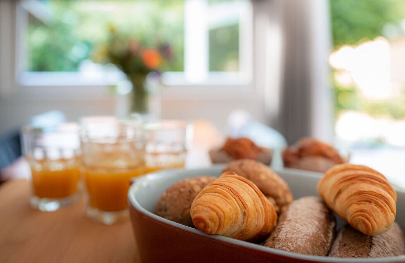 Ein Frühstückstisch mit Croissants und Orangensaft.