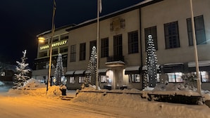 Een hotel met een bord waarop 'STORA HOTELLET' staat en een besneeuwde ingang.