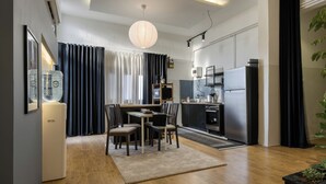 Eine moderne Küche mit Kühlschrank, Herd und Essbereich mit Stühlen und Tisch.