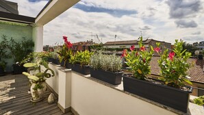 A rooftop terrace with potted plants and a view of the cityscape. - Bright Urban Terrace | Porta Romana (Milan)